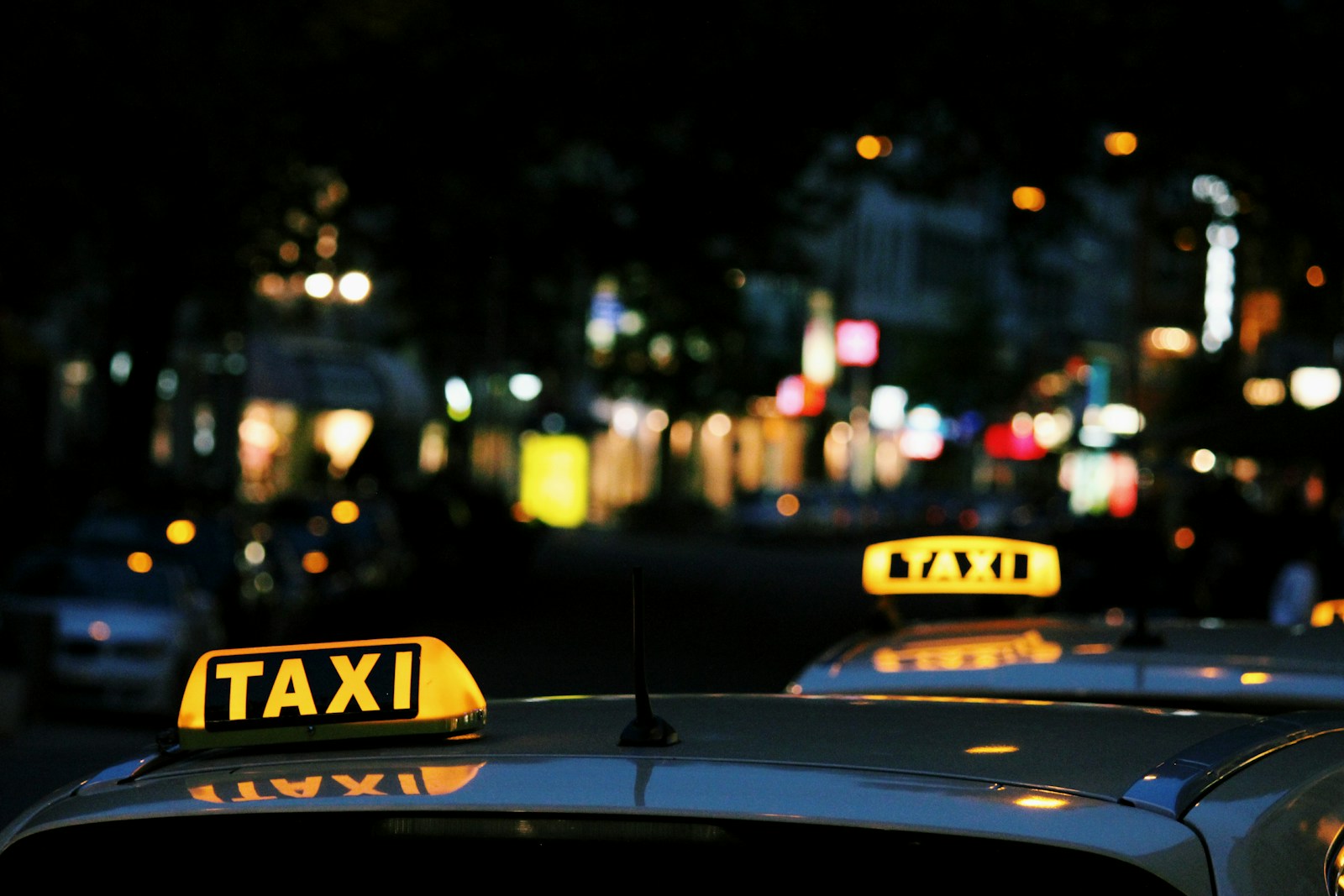 Taxi's met verlichte daklichten bij avond in de stad